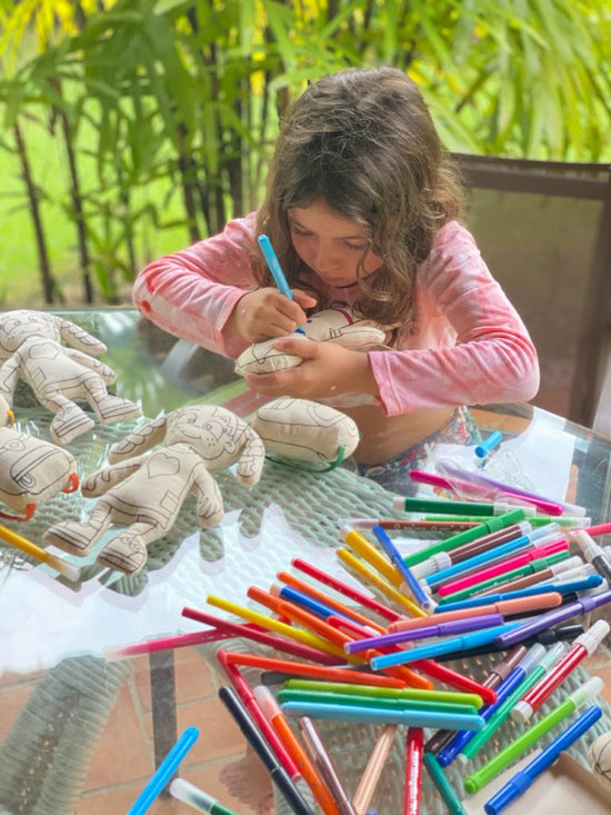 Girl coloring Kiboo stuffie with different colors of washable markers